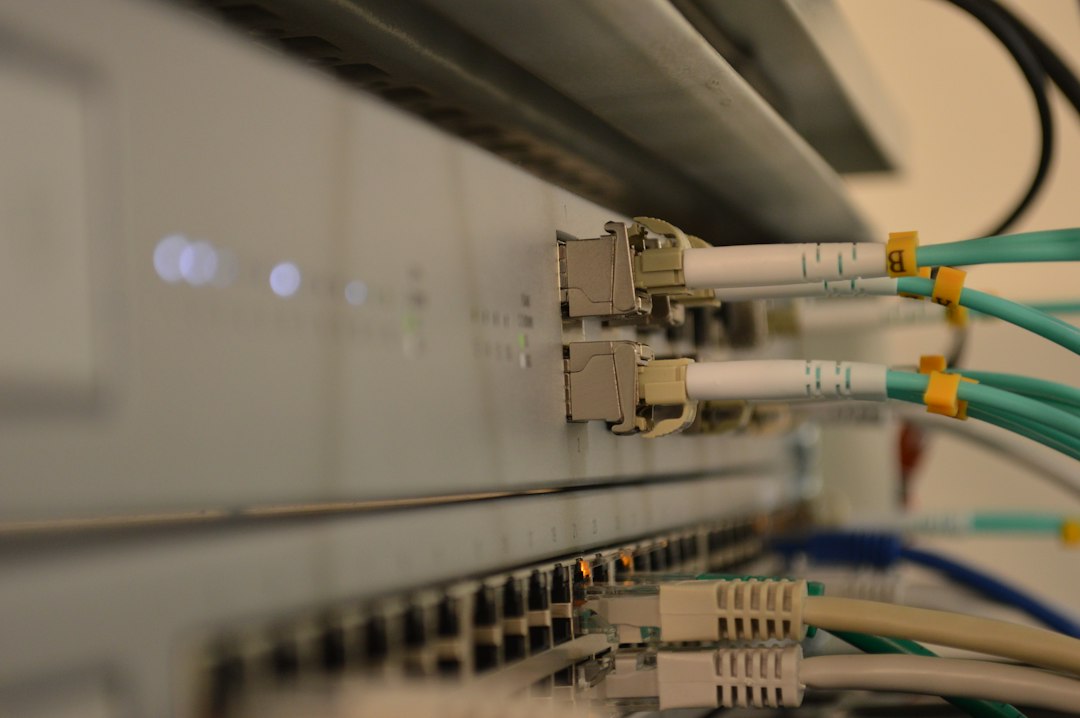 Close de cabos de fibra óptica e de rede conectados a um switch.